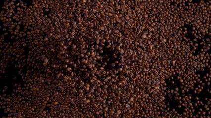 Roasted coffee beans milling in electric grinder with open cover close up.