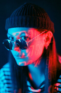 girl in hat in red and blue neon light in studio