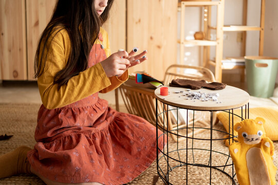 Creative girl making handcrafts at living room floor