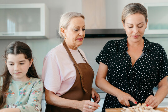 Female generation cooking together at kitchen