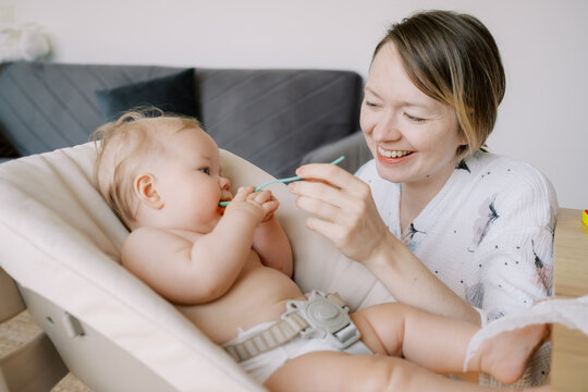 Mother Feeding Her Baby With Spoon