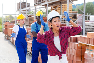 Portrait of surprised employees working in a building materials store in a warehouse who saw something extraordinary