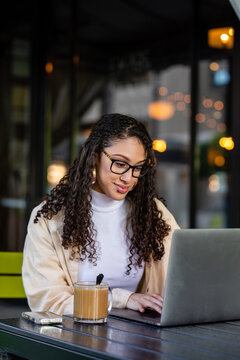 Student Concentrates While Typing On Computer At A Cafe 