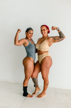 Female friends flexing biceps