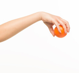 female hands holding an orange sponge ball on a white background isolated