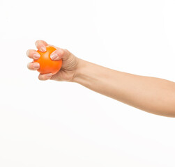 female hands holding an orange sponge ball on a white background isolated