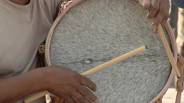 Man Playing a "Bombo Leguero", an Argentine Drum made with Wood and Animal Leather, used in Local Traditional Folklore Music. Close Up.