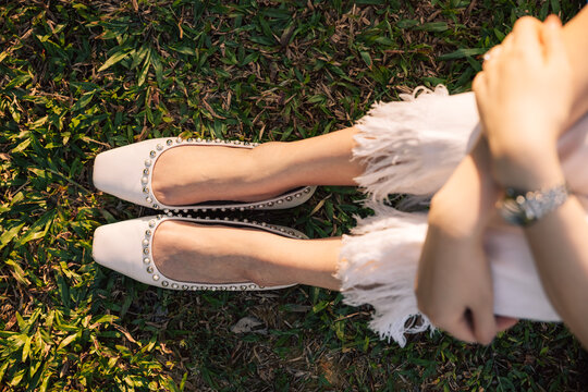 Young woman's legs and feet on grass