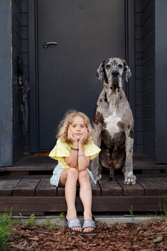 Girl and dog resting on house porch