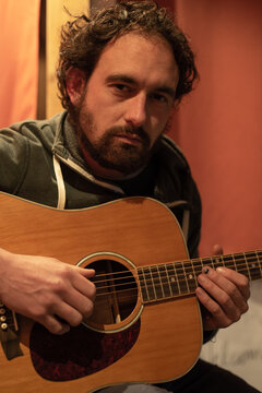Portrait of man with guitar indoor at night deep gaze