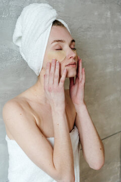 Young female applying reusable eye patches 