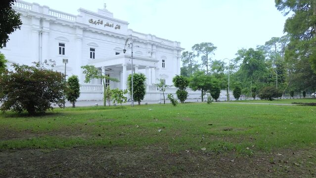 Drone approaching Quaid e Azam Library's main entrance in Lahore, Pakistan. Cinematic and smooth shot