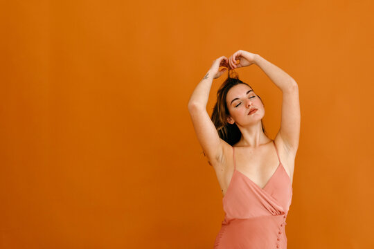 Charming woman touching hair in studio