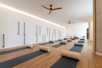 Spacious yoga studio with mats and rolls