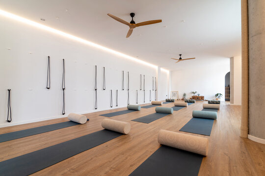 Spacious yoga studio with mats and rolls