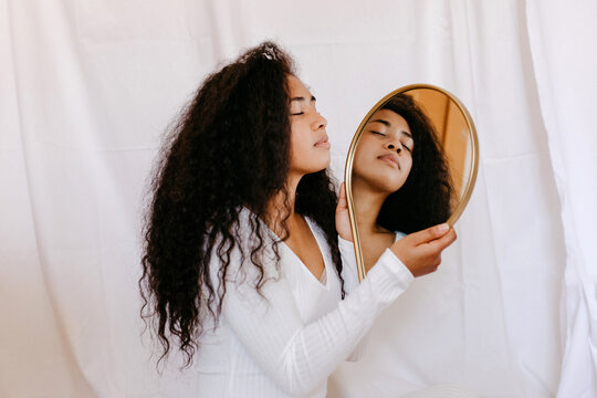 Young black woman with drop shaped mirror