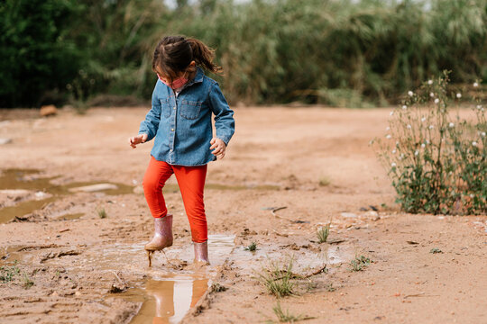 Girl in face mask standing in puddle
