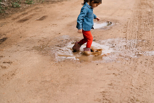 Cute girl walking in puddle
