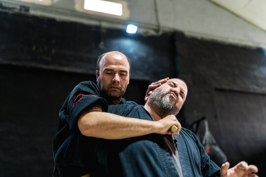Martial artists practicing throat cutting