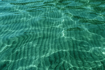Crystal clear water rippled and sunny reflections