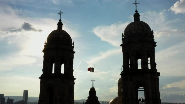 Vuelo drone sobre plaza de las americas con la basilica de zapopan de fondo templo iglesia convento silueta a contraluz 