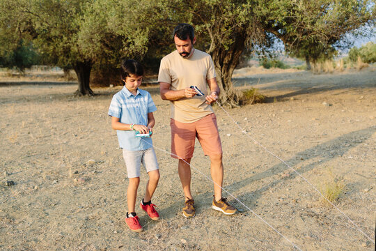 Father and son looking at the strings of the kite