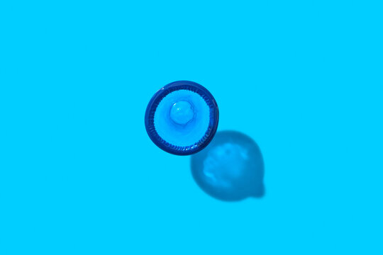 Single condom on blue background.