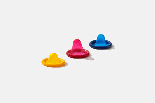 Three condoms on white background