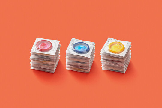 Colorful condoms stacked on white background.