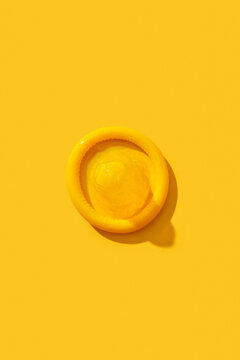 One condom on yellow background.
