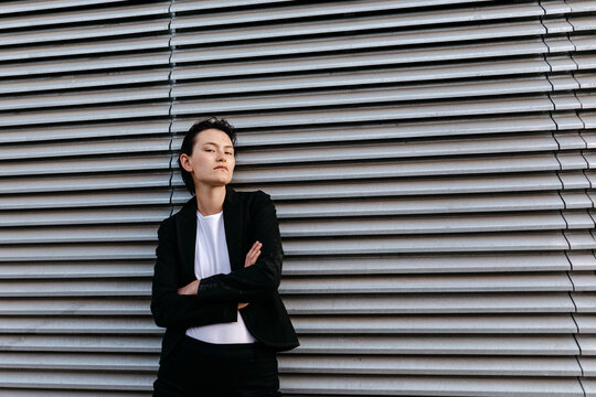 Confident non binary person near metal wall