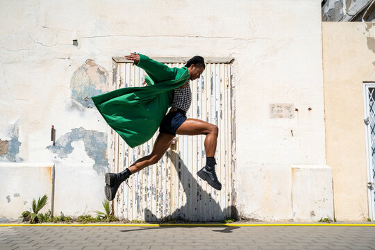 man jumping with stylish look through the city