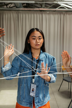 Asian woman with intertwined threads at work