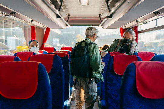 People entering inter-city bus wearing face-masks