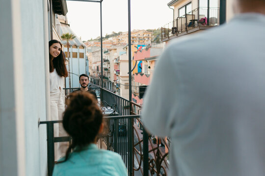 Neighbors talking through the balconies over city street