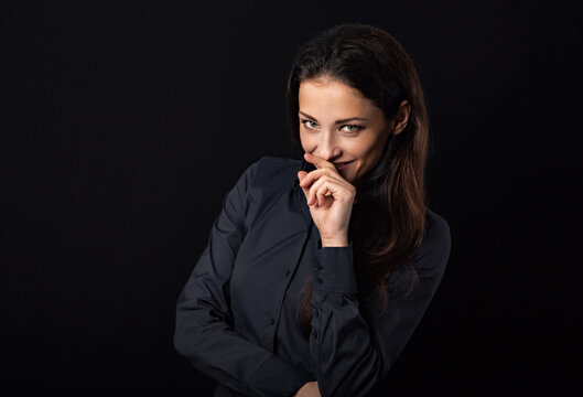 Beautiful thinking business woman with folded arms holding fingers near the face in blue shirt on black background with empty copy space for text. Closeup