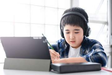 Boy teaches online class on a tablet - obrazy, fototapety, plakaty