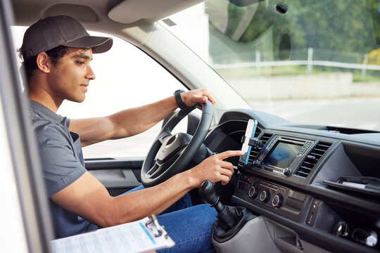 Delivery man using smartphone in van