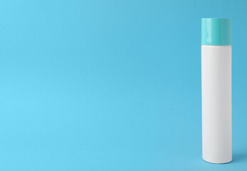 Bottle of dry shampoo on turquoise background. Space for text