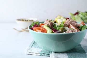 Bowl of delicious salad with canned tuna and vegetables on white table, space for text