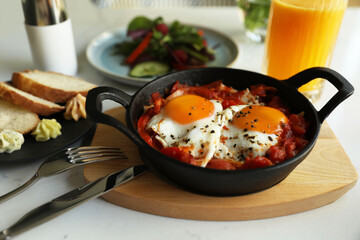 Tasty Shakshouka served on white table. Traditional Arabic dish