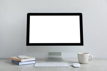 Modern computer with blank screen on light grey table. Mockup for design