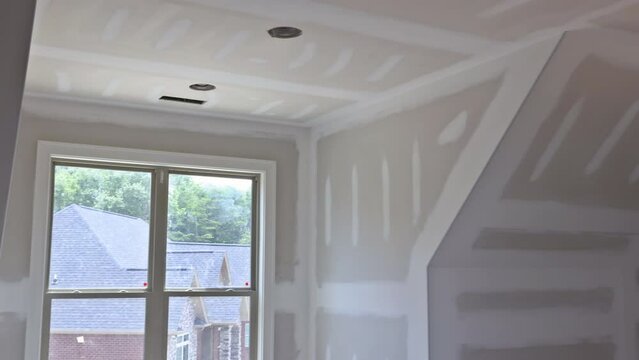 New construction of installing plasterboard in room new home drywall ready for tape
