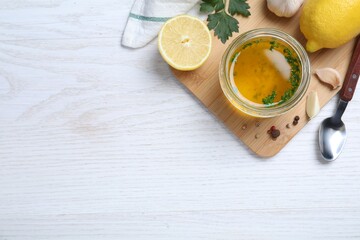 Jar of lemon sauce and ingredients on white wooden table, flat lay with space for text. Delicious...