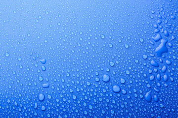 Water drops on blue background, top view