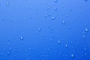 Water drops on blue background, top view