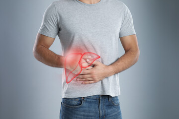 Man suffering from liver pain on grey background, closeup