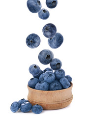 Tasty fresh ripe blueberries falling into bowl on white background