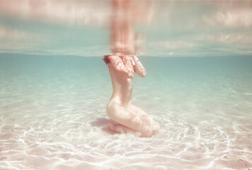 Underwater woman sitting on tropical shore