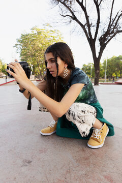 Young woman taking pictures of people skating